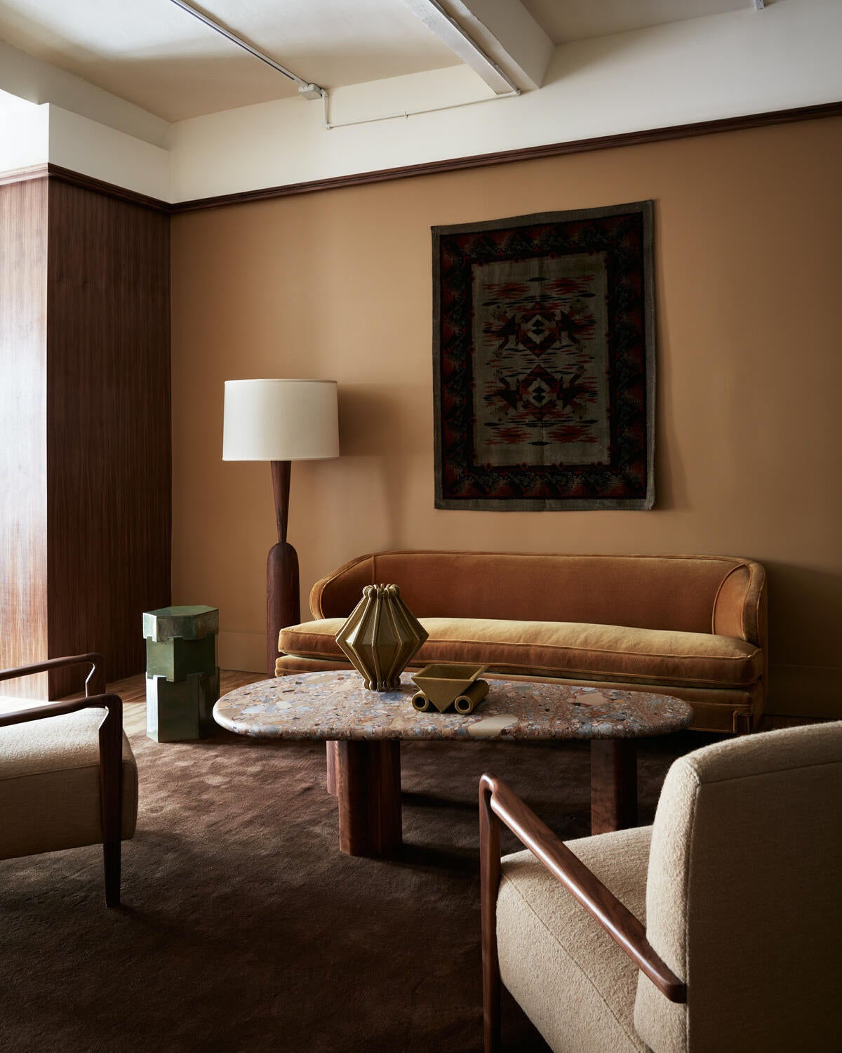 The open space is divided into a series of vignettes, using elegant walnut wing-walls and subtle shifts in color